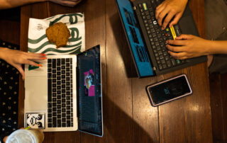 Birds-eye view of hands typing on laptops. Learn more about tips for online learning success.