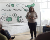 A mental health counselor leads a group class on principles of mental well-being.