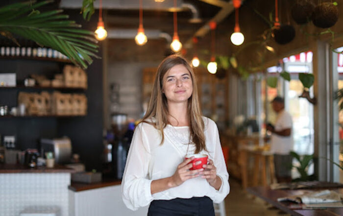 A cannabis dispensary manager enjoying her work and a cup of coffee.