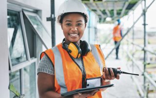 A smiling female construction manager on a construction site.