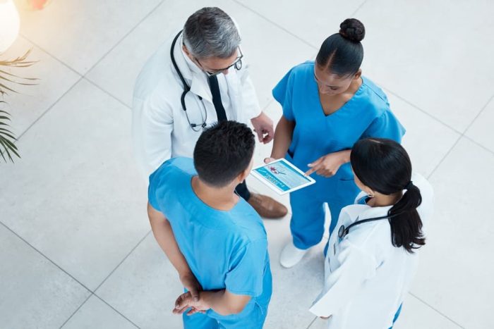 A healthcare team consults with a lead nurse to coordinate patient care