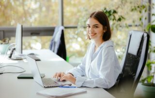 A city worker smiles while working on her office laptop