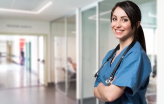 Portrait of a smiling nurse standing in a hospital corridor.