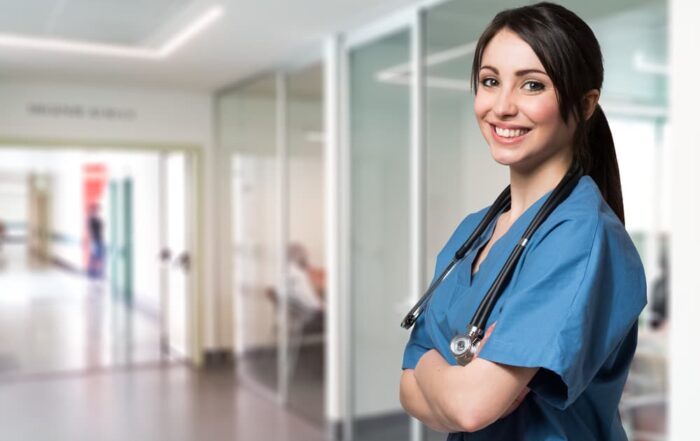 Portrait of a smiling nurse standing in a hospital corridor.